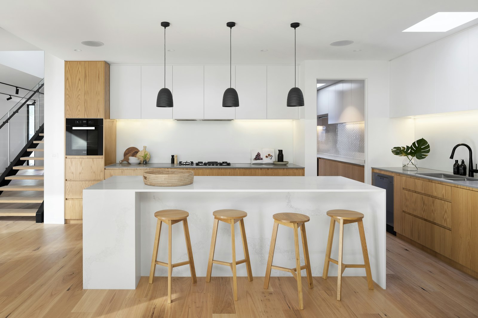 The morning kitchen: a marble waterfall island under the skylight