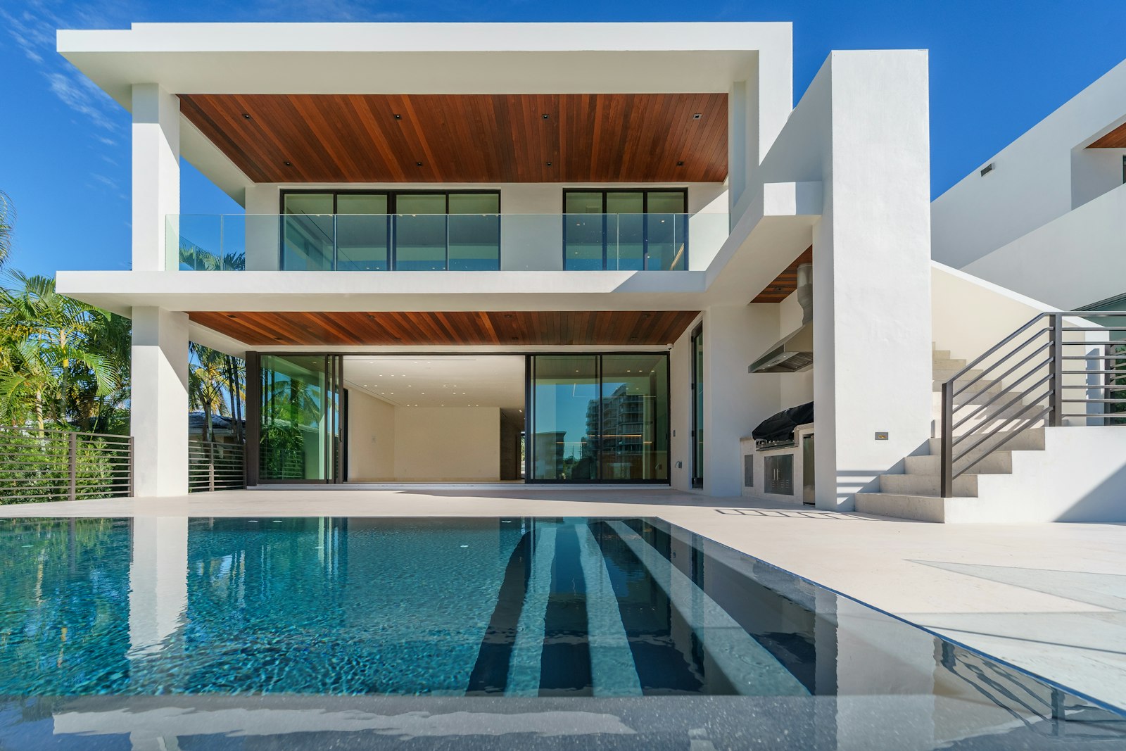 The west terrace pool at midday, the villa's deep roof carrying the shade