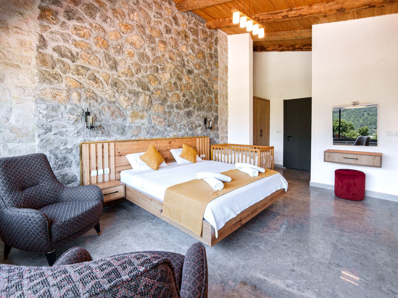 A designer bedroom against a full stone wall